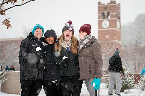 Students in the snow in front of the alumni tower
